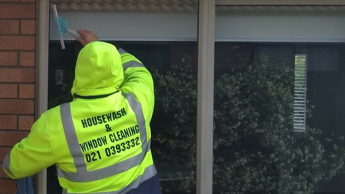 Luke from Spotfree cleaning a window with professional equipment